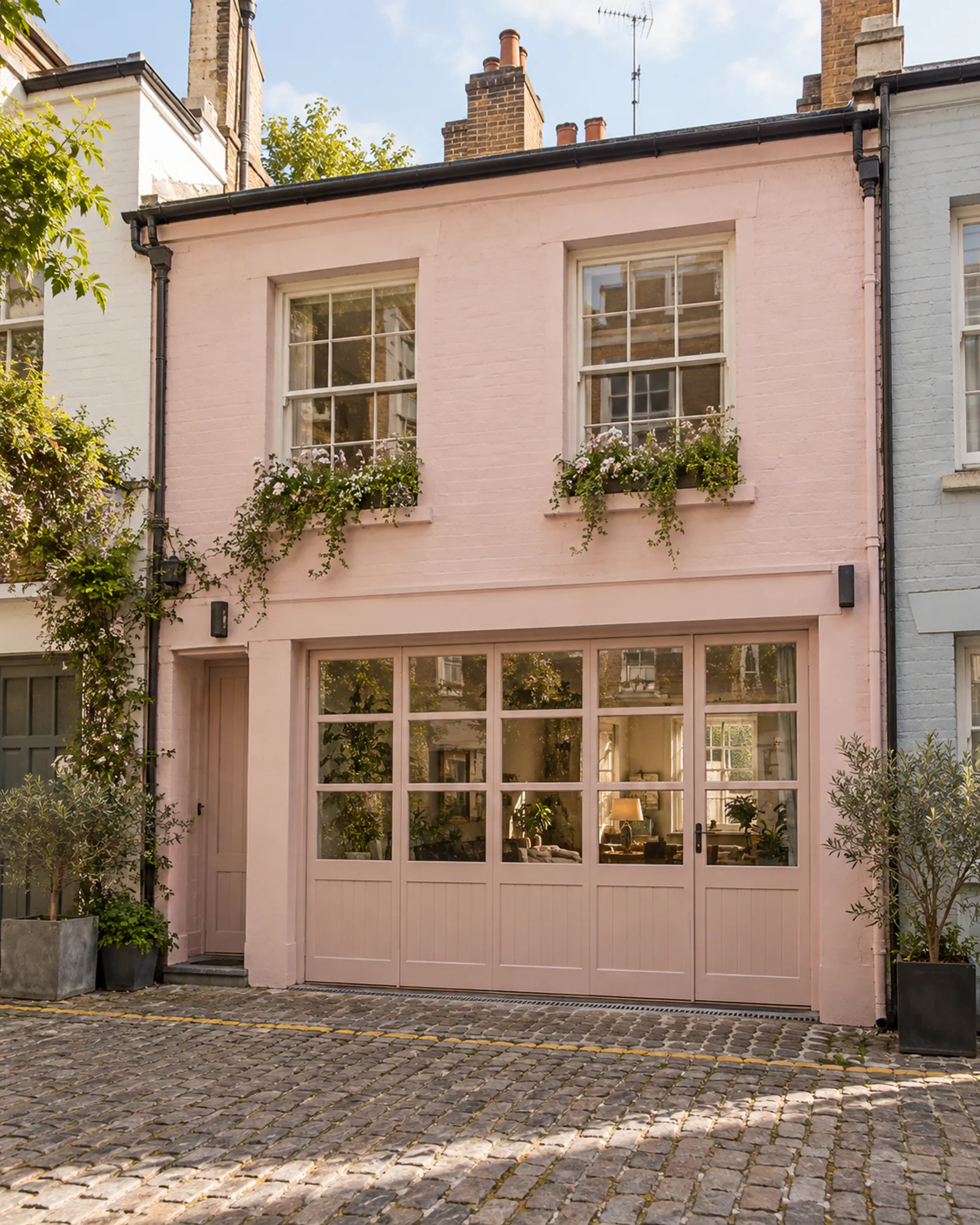 Pink mews house on a cobbled lane